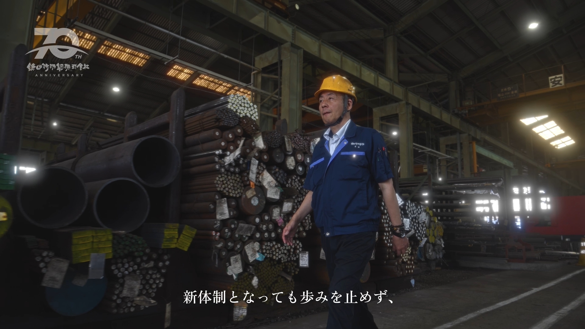 鋼材の間を歩く社員